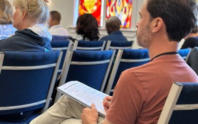 Man sitting taking notes in a School of Healing Prayer class.